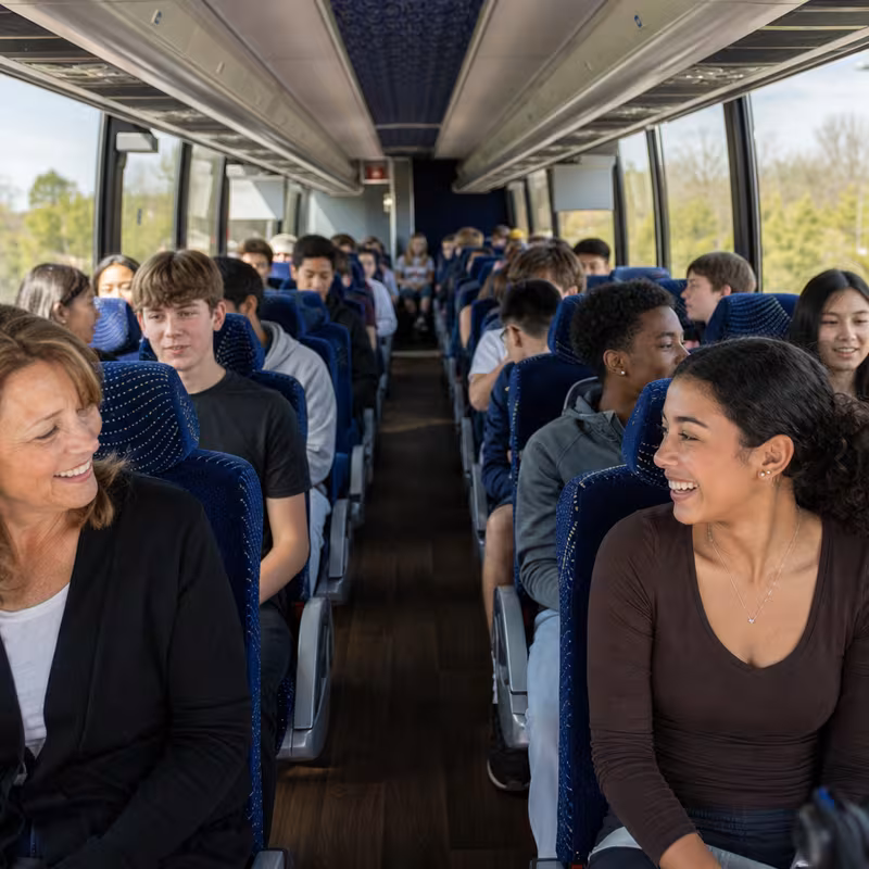Group boarding a white charter bus for School Transportation transportation in Scottsdale